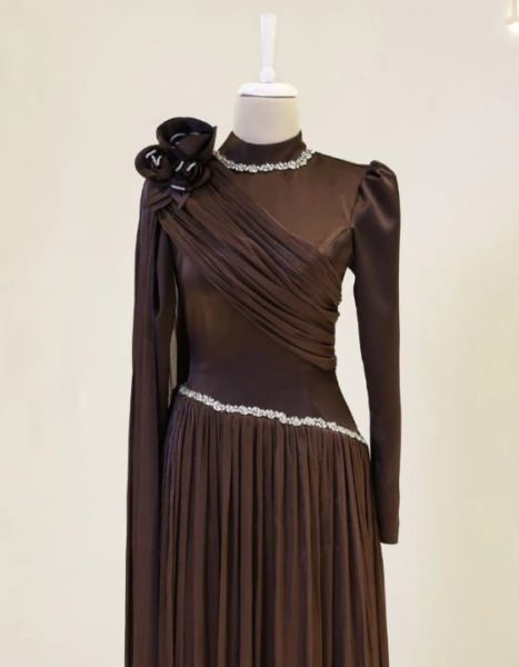 Détail du haut de la robe de soirée chocolat Modest, mettant en valeur l'ornement floral à l'épaule, le col montant et les finitions perlées